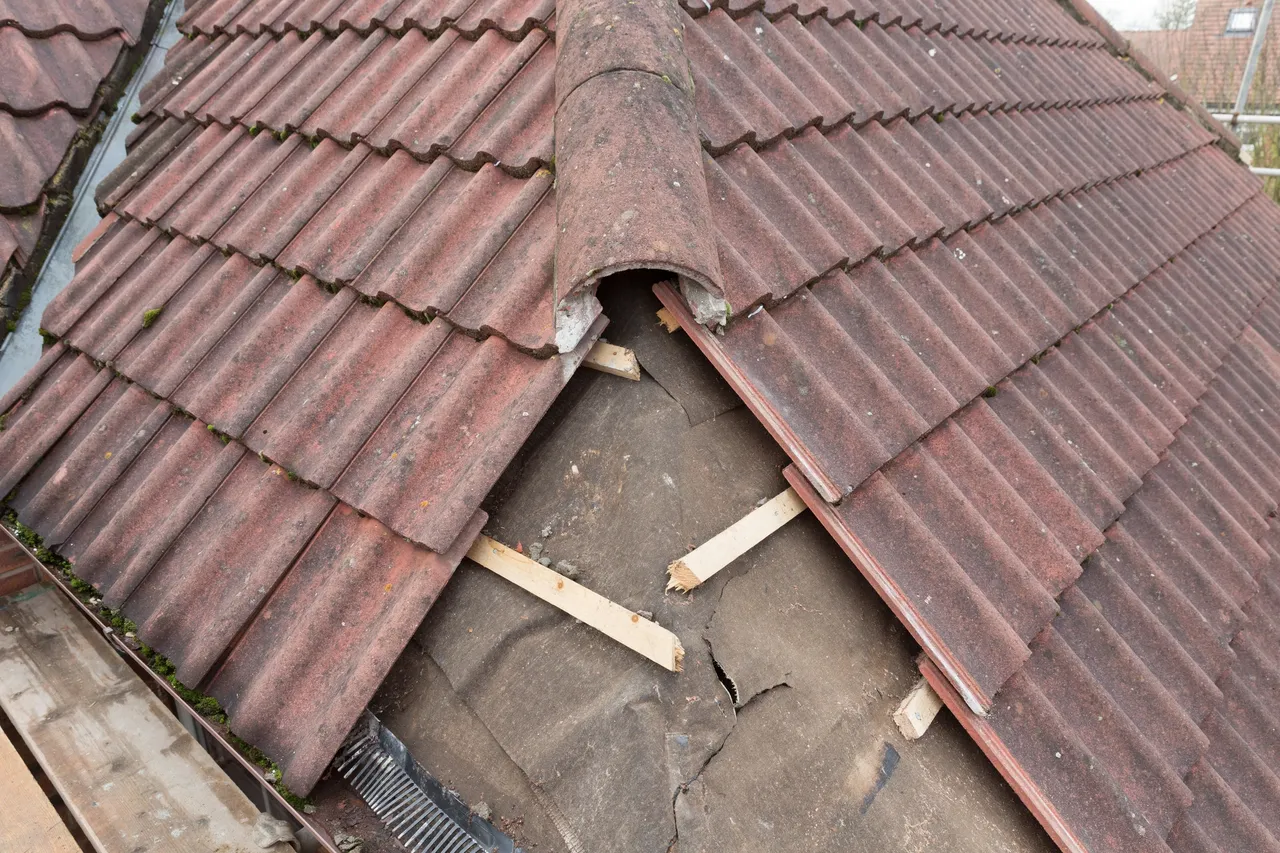 Damaged clay tile roof requiring repair before reroofing works